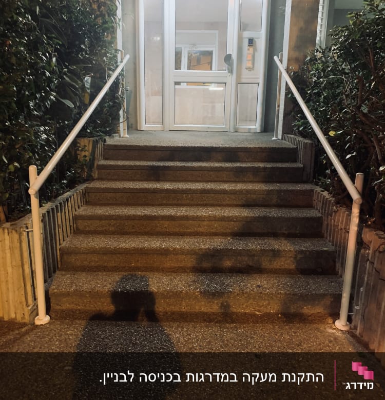 דלת זכוכית עם מסגרת לבנה בכניסה לבניין